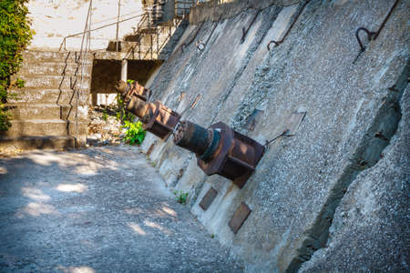 anchor bolts in the concrete wall, protecting the house from falling down the slopeの写真素材