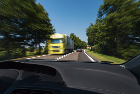 Driving in good weather conditions, passing yellow truckの写真素材