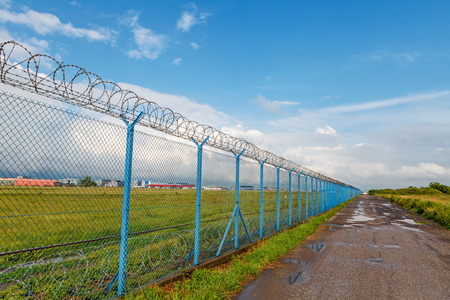 Barbed wire fence of the restricted area under blue skyの写真素材