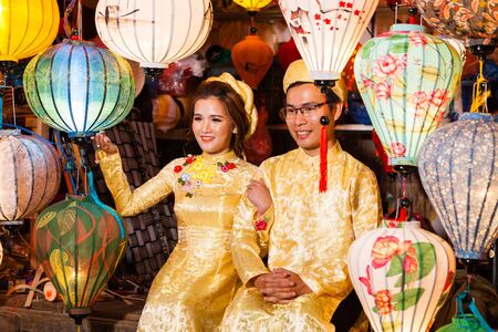Hoi An, Vietnam - march 11 2017: vietnamese brides in traditional costume against colorful lanterns, Full Moon festival nightのeditorial素材