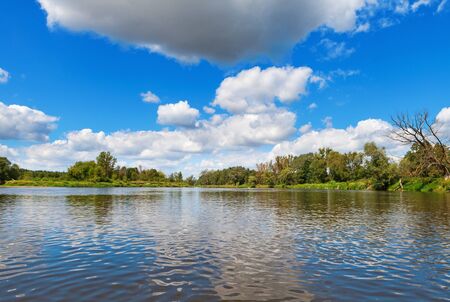 Blue cloudy summer sky over Bug river, Poland, Europeの写真素材