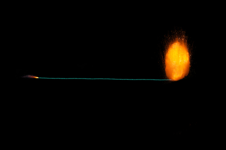 Burning fuse with realisic fiery explosion at the end, orange color with sparks isolated on black backgroundの写真素材