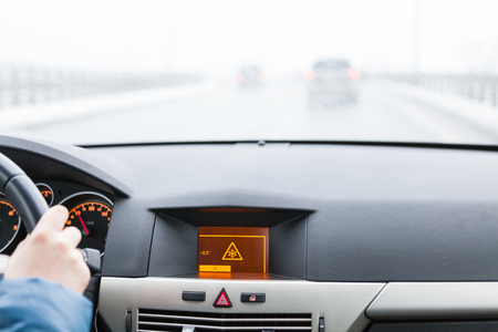 Slippery road warning on car display, car interior point of viewの写真素材