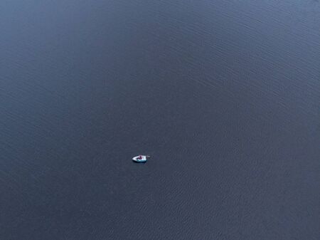 Lonely fisherman in the middle of the lakeの写真素材