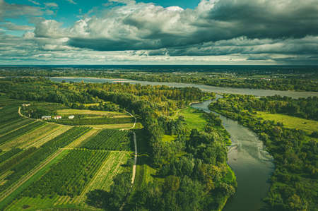 Fields and Vistula river under moody cloudy skyの写真素材