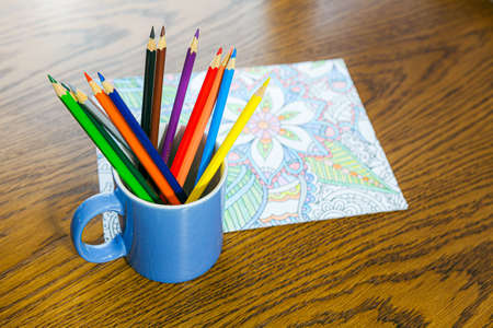 Adult coloring book and crayons on the tableの写真素材