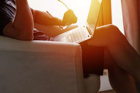Working from home on the laptop. Wearing casual comfort outfit in home office.の写真素材