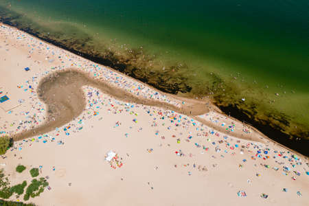 Baltic coast, people having bath in the sea and in the Oliwski stream mouth to the sea during hot...