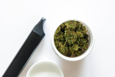 Cannabis flos, medical marijuana in white container next to vaporizer, safe way to take medicineの写真素材