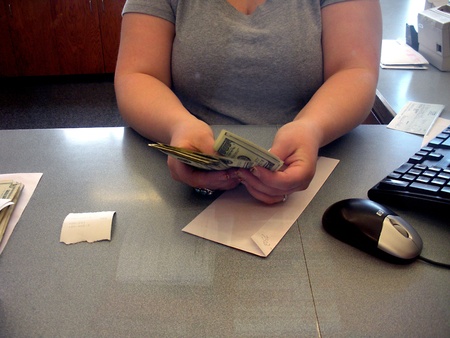 LEWISTON/IDAHO/USA _Female  Cashier countting US Dolloar notes bill at Potlatch Federal Credit Union bank 14 March 2011      のeditorial素材