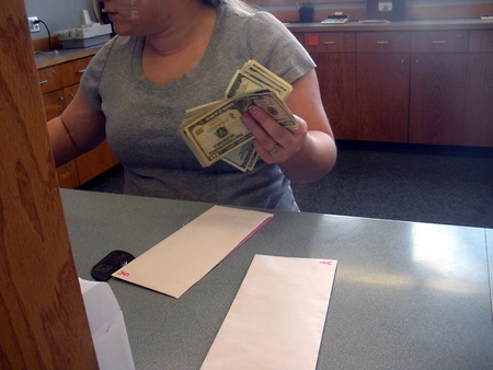 LEWISTON/IDAHO/USA _Female  Cashier countting US Dolloar notes bill at Potlatch Federal Credit Union bank 14 March 2011    のeditorial素材