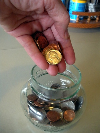 LEWISTON/IDAHO/USA _  Grandmother saves coin for grand d child  and uses coins acounting machine for actual amount  at pptlapch federal credi union  14 March 2011     のeditorial素材