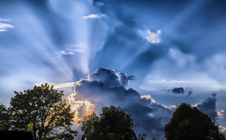 - the sunset sun behind the cloudsの写真素材