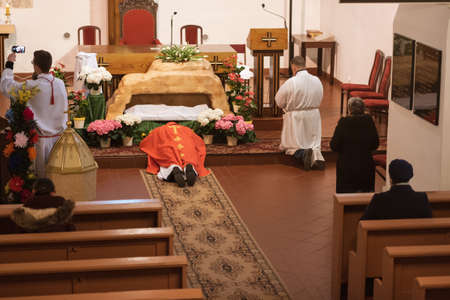 TYMOWA, POLAND - APRIL 10, 2020. The Passion liturgy in the Church Our Lady of Queen during Good Friday. Priest lying on the floor. Due to the pandemic Covid-19 coronavirus can be only up to 5 faithful in the church.のeditorial素材