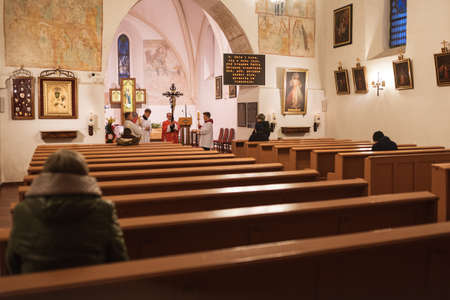 TYMOWA, POLAND - APRIL 10, 2020. The Passion liturgy in the Church Our Lady of Queen during Good Friday. Priest holding crucifix. Due to the pandemic Covid-19 coronavirus can be only up to 5 faithful in the church.のeditorial素材