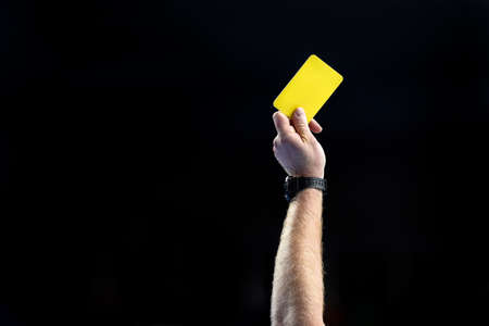 referee hand with yellow cardの写真素材