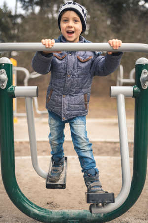 Boy exercising at an outdoor gym in the parkの写真素材