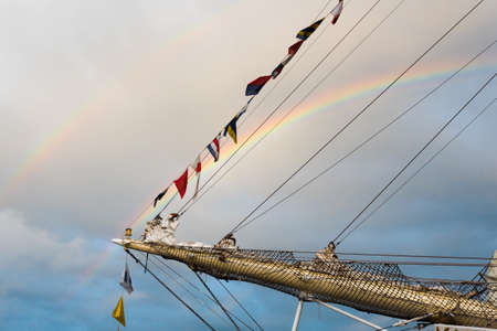 Detail of a tall sailing ship with a double rainbow in the backgroundの写真素材