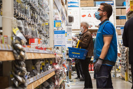 LUBIN, POLAND - APRIL 21, 2020. Customers with face masks due to coronavirus pandemic, in the Castorama building supermarket,のeditorial素材