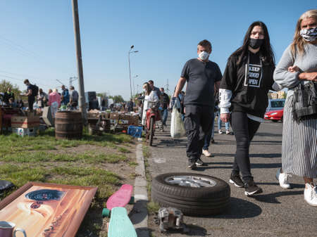 LUBIN, POLAND - MAY 9, 2020.  City stock exchange during a pandemic Covid-19. People passing by the painting with people covered faces.のeditorial素材