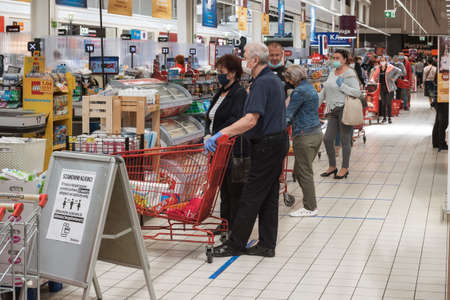 WROCLAW, POLAND - MAY 22, 2020. Customers in line to the checkout in Carrefour supermarket. Due to coronavirus pandemic people have face masks.のeditorial素材