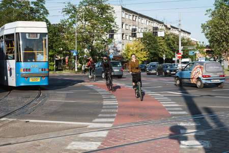 WROCLAW, POLAND - MAY 22, 2020. Cyclists cross a road intersection Due to coronavirus pandemic they...