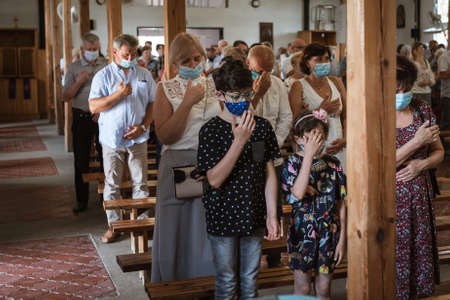 LUBIN, POLAND - JULY 19, 2020. Holy Mass in the Church. Due to the pandemic Covid-19 coronavirus people have face masks.のeditorial素材