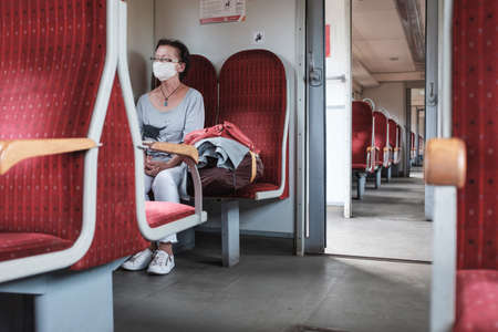 WOLOW, POLAND - SEPTEMBER 23, 2020. Woman with face masks due to coronavirus pandemic in the train.のeditorial素材