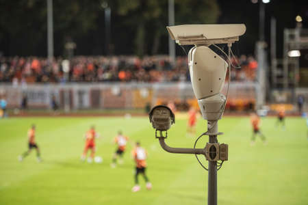 CCTV camera at football stadium with match in the backgroundの写真素材