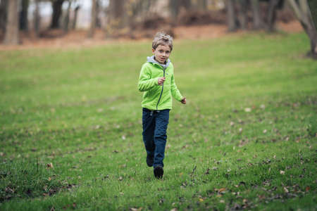 Young boy runing in the old orchard.の写真素材
