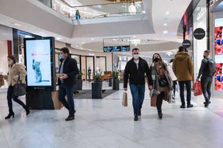 WROCLAW, POLAND - DECEMBER 13, 2020. People with face masks and shopping bags in shopping mall Wroclavia.のeditorial素材