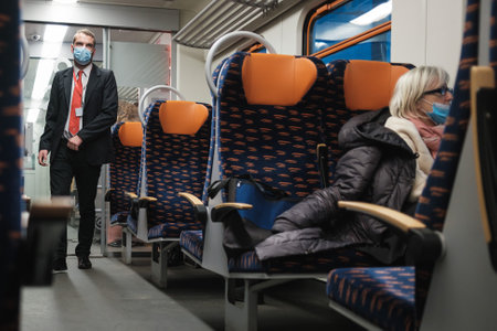 WOLOW, POLAND - JANUARY 9, 2021.guard with face mask due to coronavirus pandemic in the train.のeditorial素材