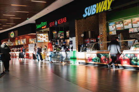 WROCLAW, POLAND - FEBRUARY 1, 2021. People with face masks in the gastronomy zone in shopping mall...