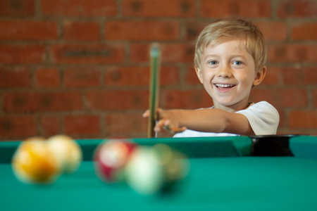 5-6 years old boy playing billiardsの写真素材