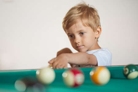 5-6 years old boy playing billiards