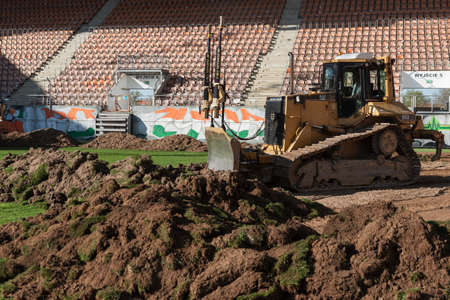 LUBIN, POLAND - MAY 11, 2021: Stadium of soccer team KGHM Zaglebie Lubin. A bulldozer removes turf on a soccer field.のeditorial素材