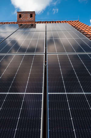 Photovoltaic panels on the roof and intaller in the backgroundの写真素材