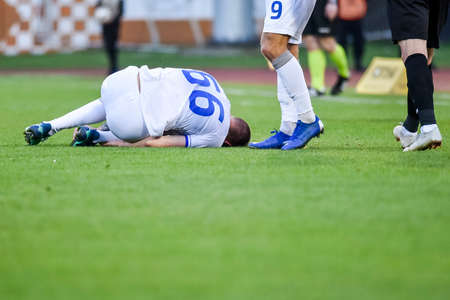 The injured footballer lies on the pitch.の写真素材