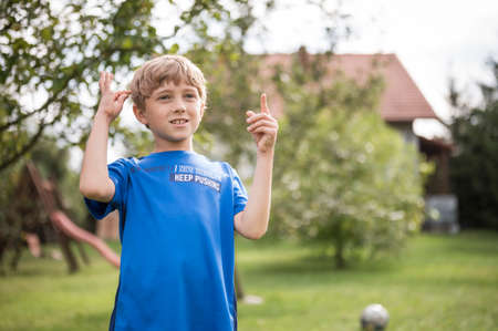Portrait of the excaiting cute 9 years old boy with summer sunlight on his faceの写真素材