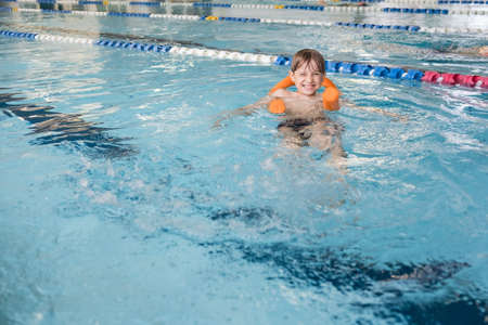The boy learning to swim in the indoor poolの写真素材