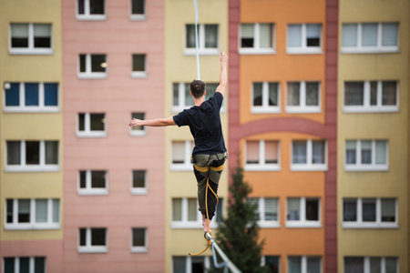 A tightrope walker is walking on the rope at a high altitude.の写真素材