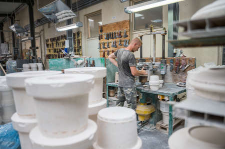 BOLESLAWIEC, POLAND - AUGUST 22, 2021: A Worker of a ceramics factory Manufaktura shows his work during the Pottery Festival in BolesÅawiec.のeditorial素材