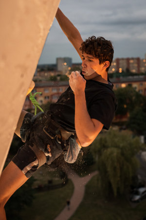 LUBIN, POLAND - SEPTEMBER 25, 2021: VIII Memorial of Iwona Buczek in climbing on difficulty. Young man during climbing and cityscape in the background.のeditorial素材