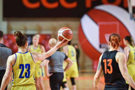 Woman keeps the ball during basketball match.の写真素材