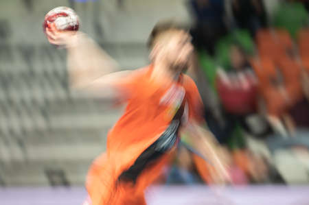 Blurred silhouette of handball player throwing a ball.の写真素材