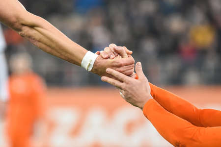 Hands detail - football player helps his opponent.の写真素材
