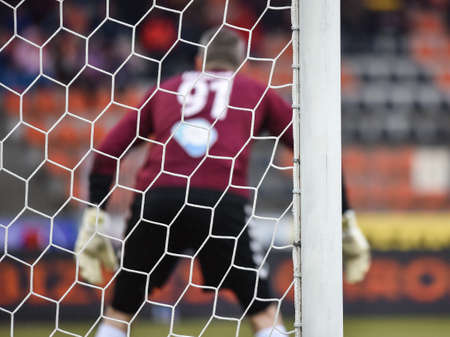Detail of goal's post with net and football goalkeeper in the background.の写真素材