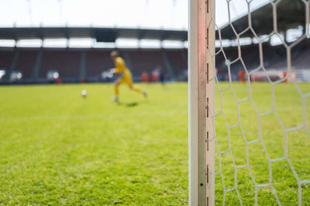 Soccer goal post and soccer match in the backgroundの写真素材