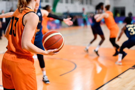 Woman player keeps the ball during basketball match.の写真素材