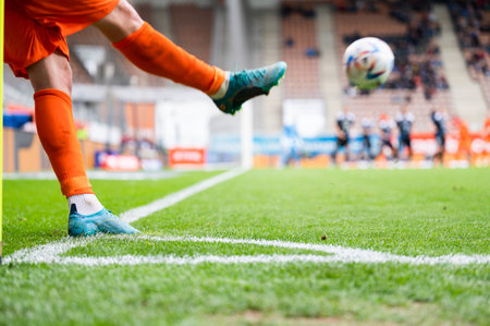 Footballer takes the corner. Detail of player's legs and the ball during soccer match.の写真素材